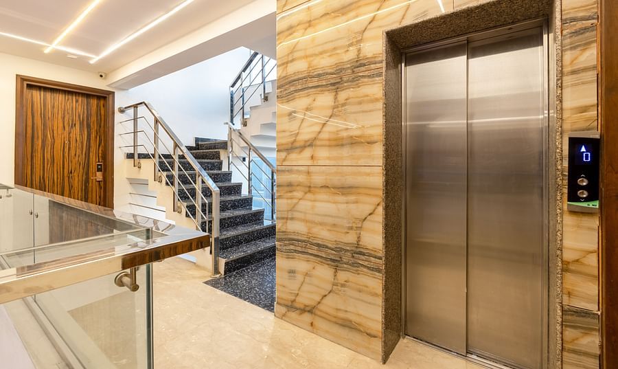 Hotel corridor with an elevator and staircase at Hotel Bawa, Gurgaon.