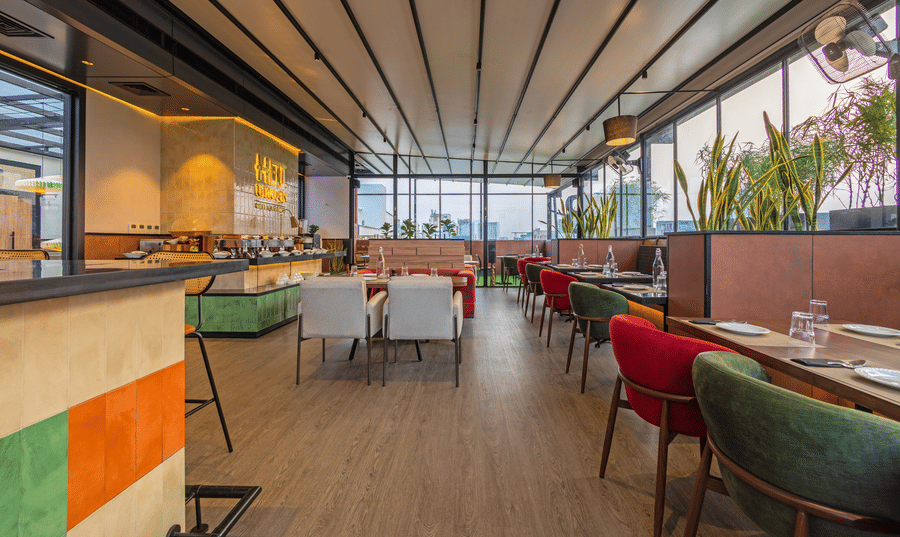 Dining floor at Koi Garden restaurant. Tables and seating options are arranged across the room. A buffet counter stands on the left side under ceiling panels.