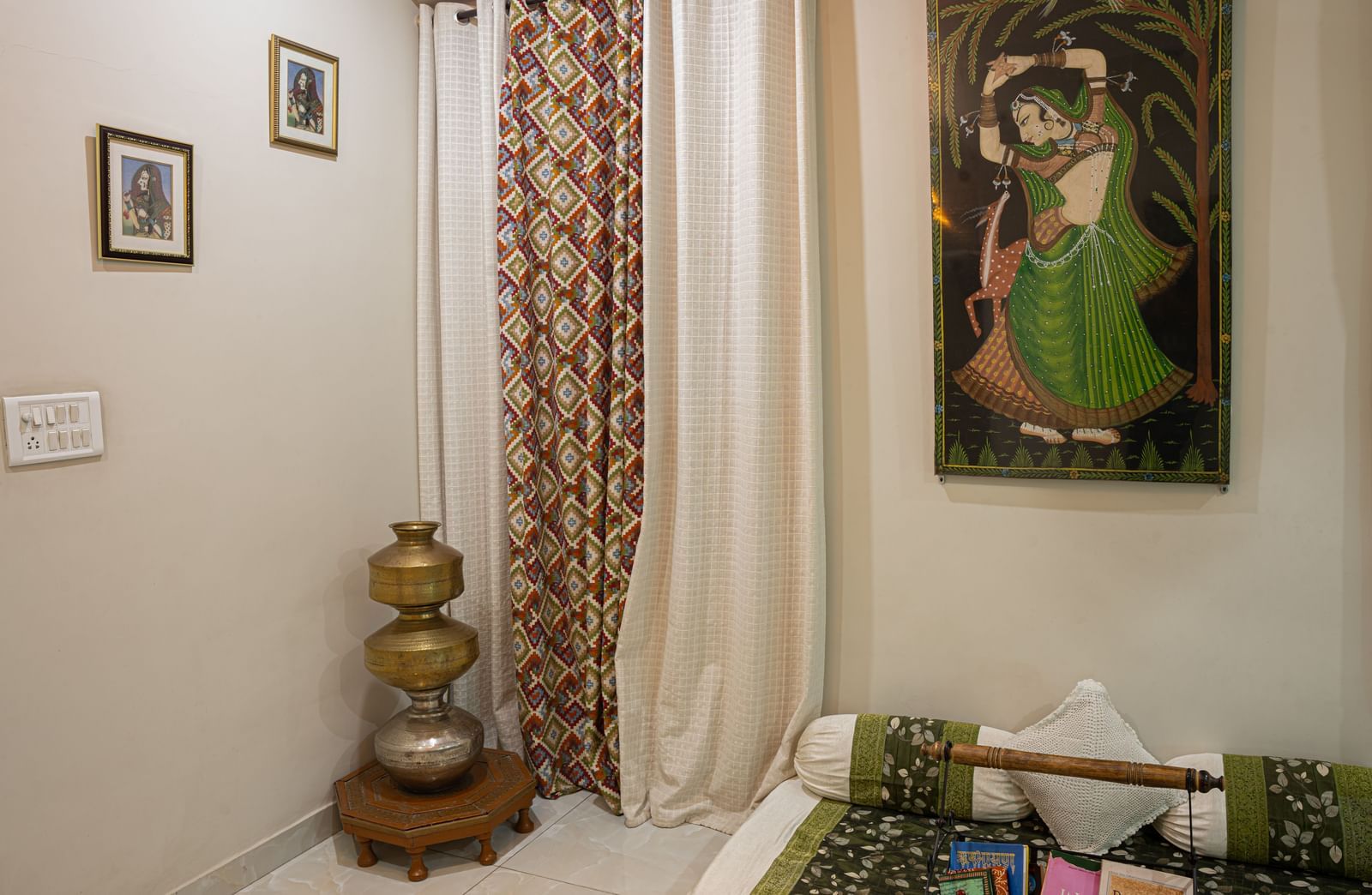 Room with window curtains, floor decorations, a large portrait painting, and sofa furniture at Jaypore360 Homestay in Jaipur.