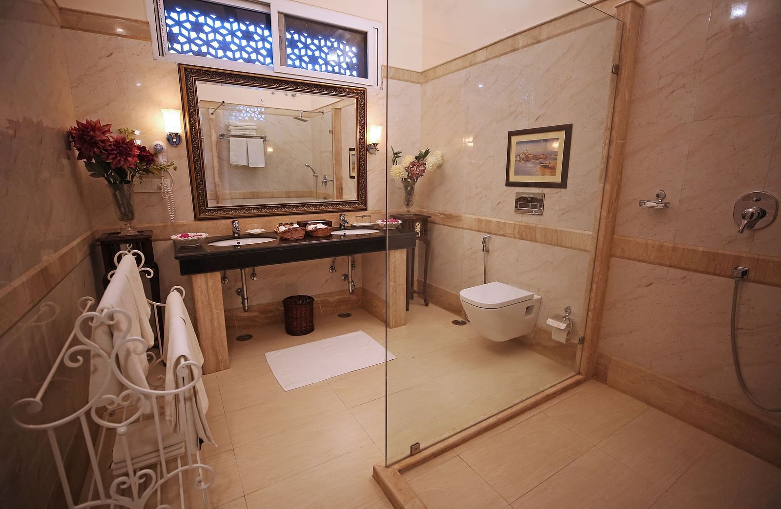 A modern and clean hotel bathroom featuring a large mirror, basin, and walk-in shower - Khas Bagh, Jaipur.