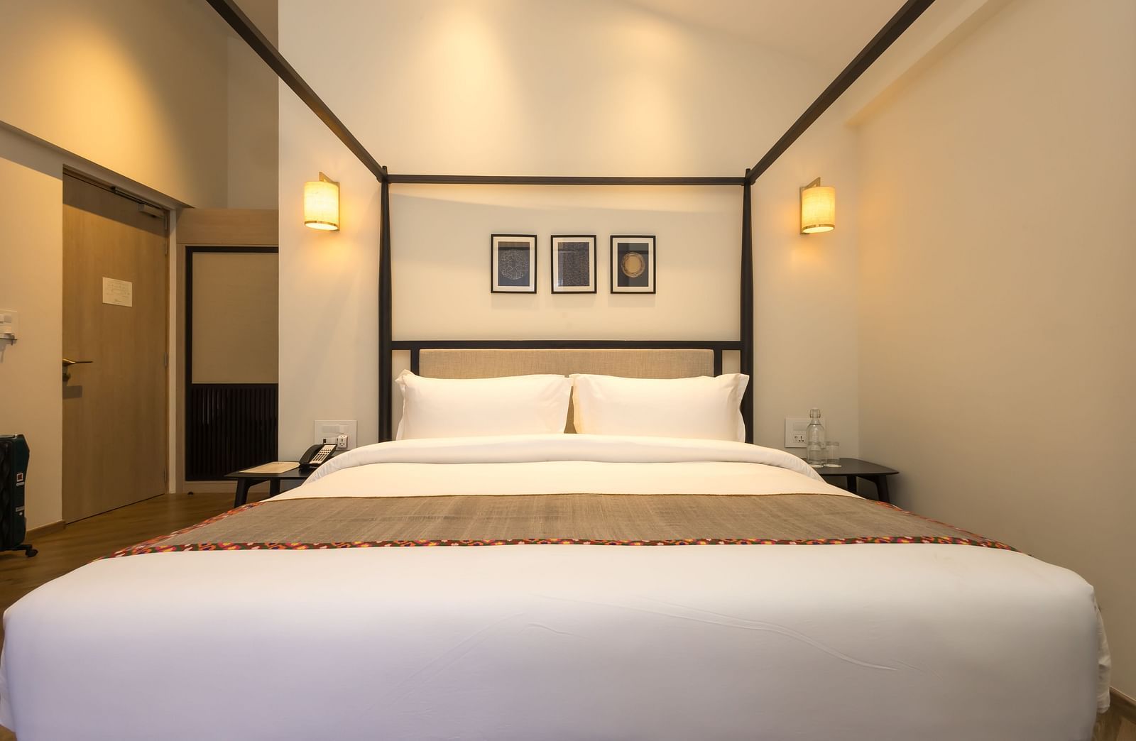 Bedroom with a four-poster bed and white linens at Nivasana Manali.