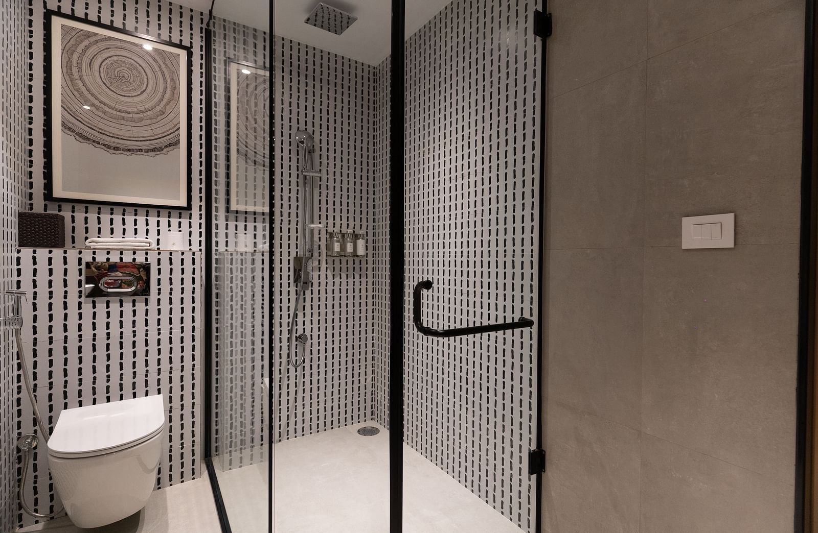 Modern bathroom with glass partition separating the toilet and shower area at Nivasana Manali.