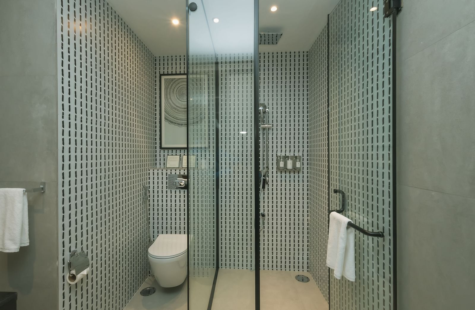 Modern bathroom with a shower area separated with glass panels at Nivasana Manali.