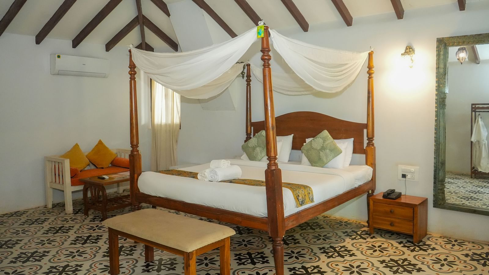 A room with a four-poster bed and seating area at at De Soul Santé, Morjim.