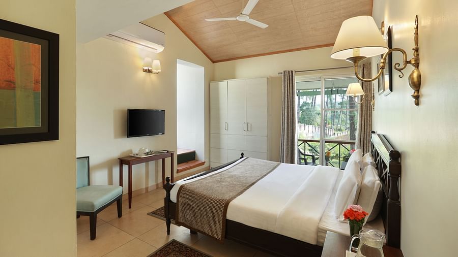 A posh bedroom with white linens, designed with soft hues of white and features room amenities - Lamrin Norwood Green, Palampur