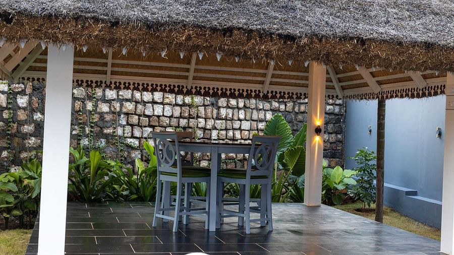 image of the outdoor seating area with wooden chairs and a table under the gazebo - Darza Resorts