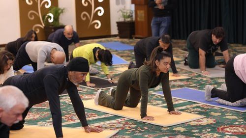 A group of people performing yoga on top of their yoga mats at Heritage Village Resorts & Spa