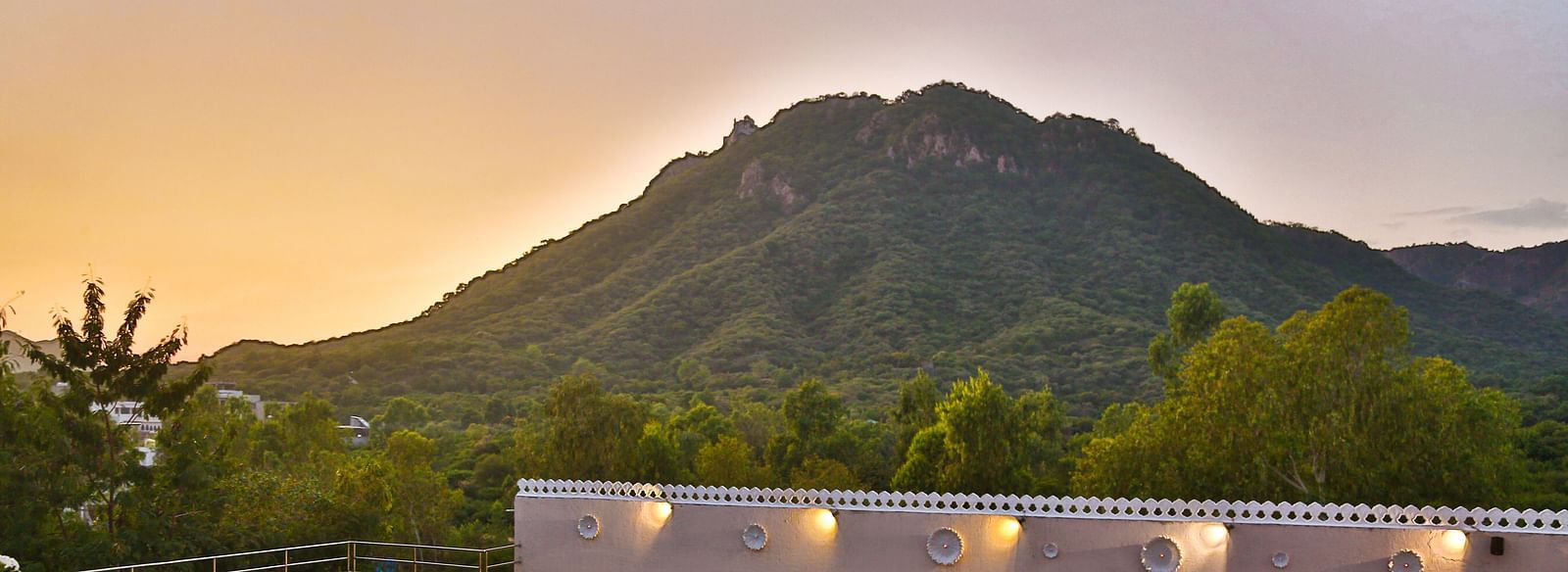 A pool with a view of mountains. - Bamboo Saa Resort & Spa, Udaipur