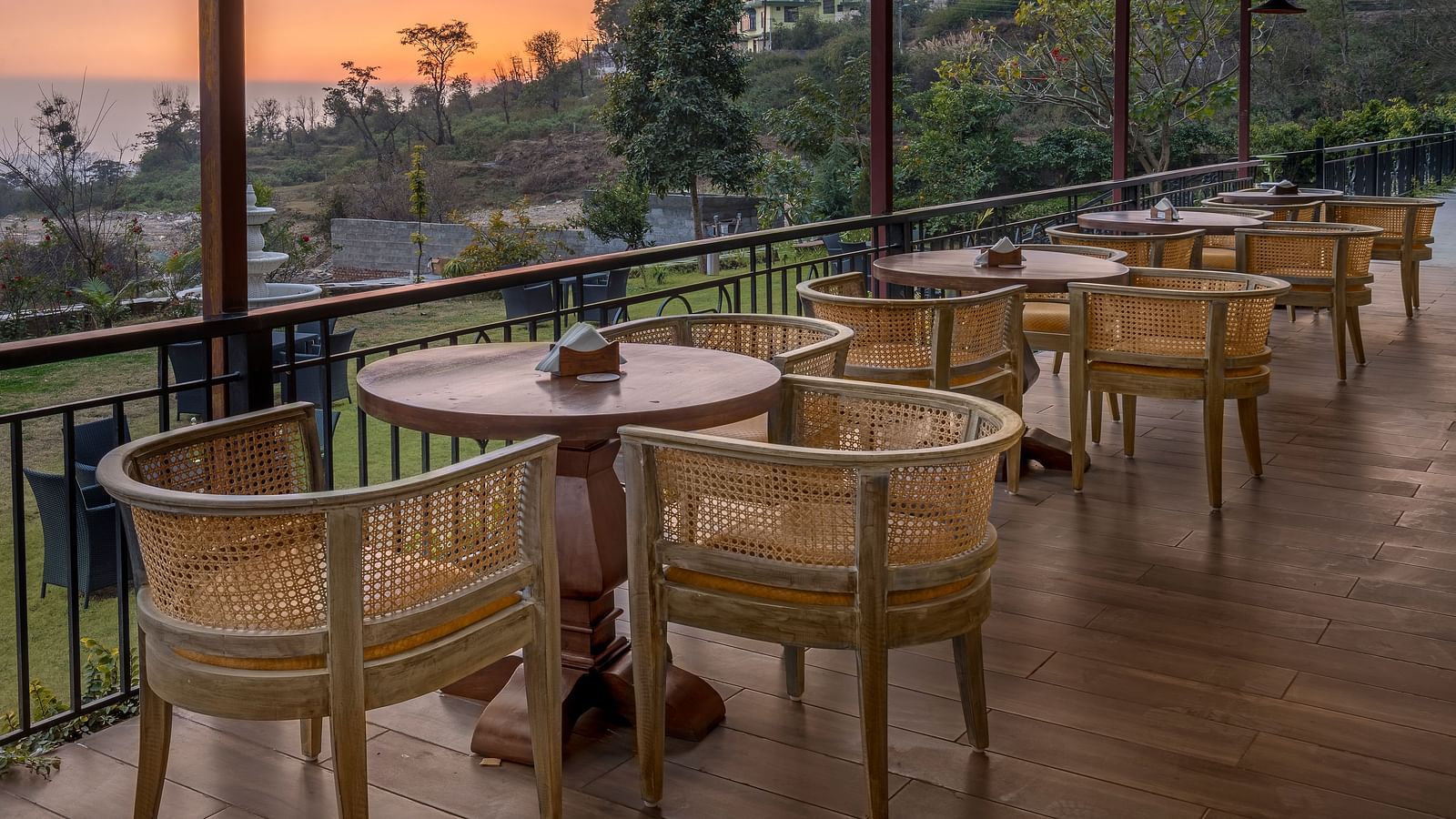 An image of Outdoor seating area with a view of lush trees and mountains at Atman, dharamshala.
