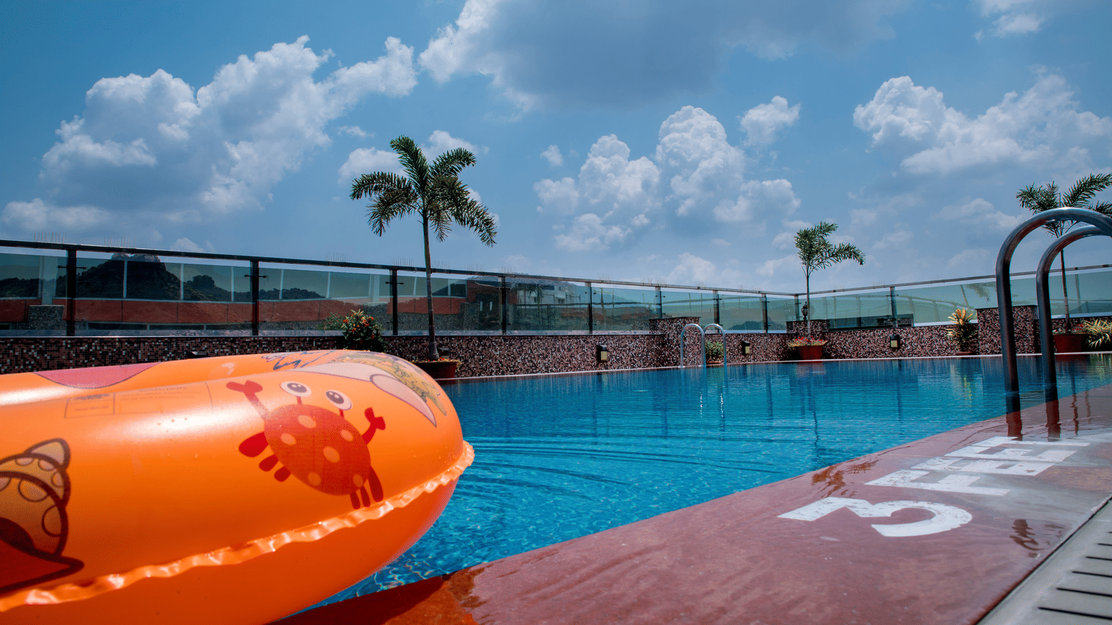 The rooftop swimming pool with an orange floating tube at the Benzz Park, Vellore.