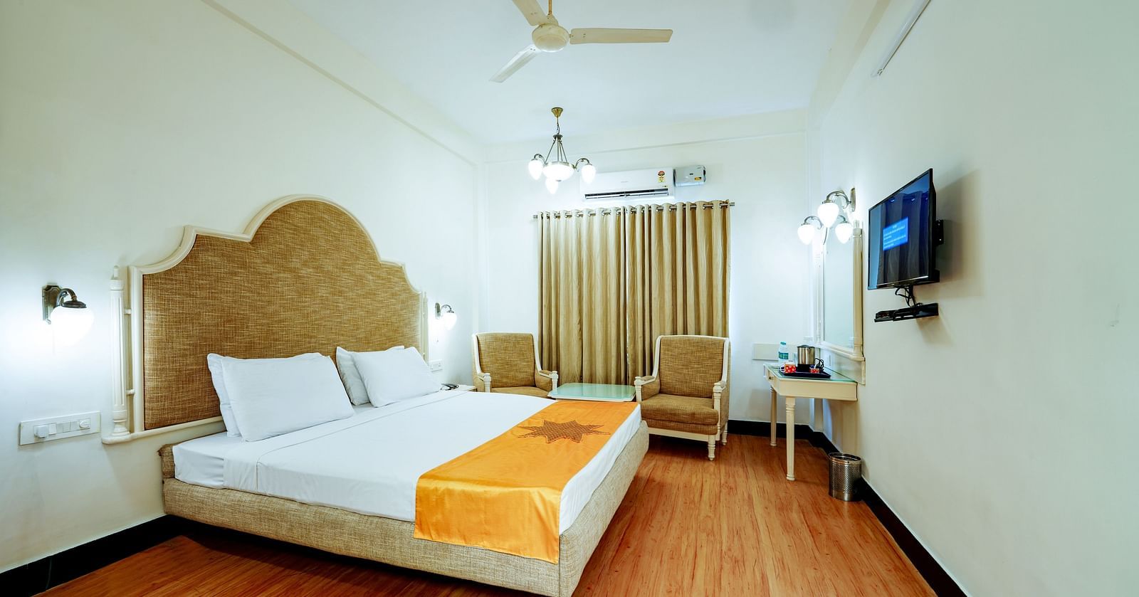 The hotel room from a different angle, emphasizing the space and the wooden floor at Greens Inn - Spacious Accommodation in Ramoji Film City.