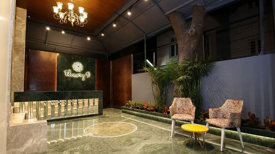 An image of a huge reception lobby  featuring a desk and two chairs with centre table at one corner - Theory9 - Premium Service Apartments, Bandra
