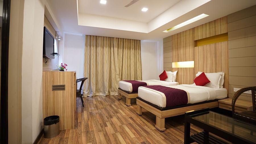 an image of a executive deluxe room with twin beds and a television  