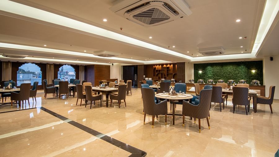 A shot of Ruttba, one of the best restaurants in Dehradun featuring chairs and tables with warm interior lighting - DLS Grand Luxotica
