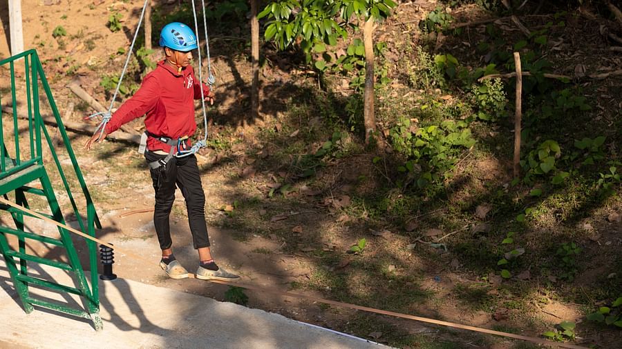 Adventure activity featuring a person preparing for a zip line experience | Stone Wood Jungle Resort, Dandeli