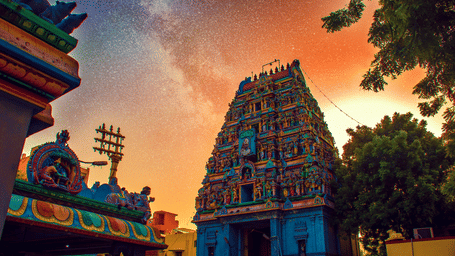 Temple and trees under a colourful sky.