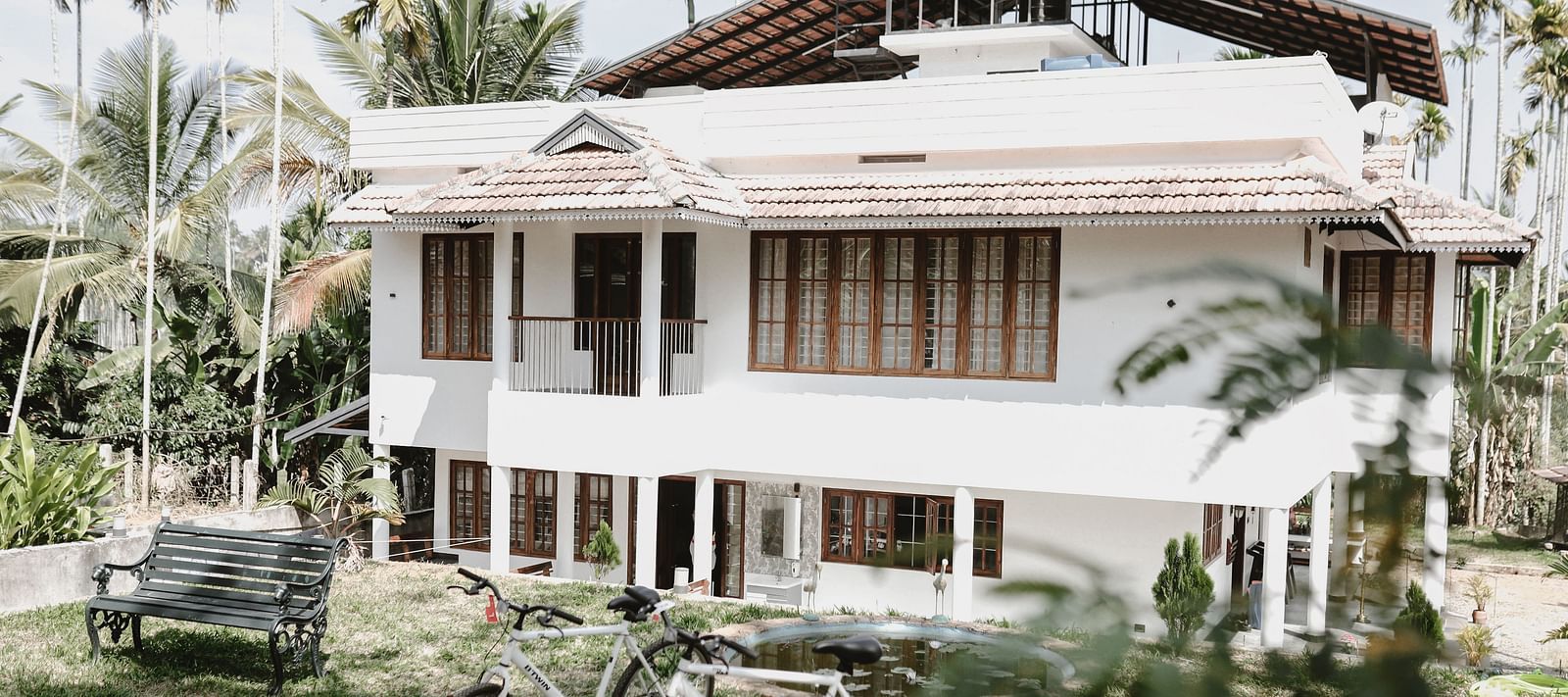 2 bicycles standing in front of the Facade of Ananda Holiday Home, Wayanad