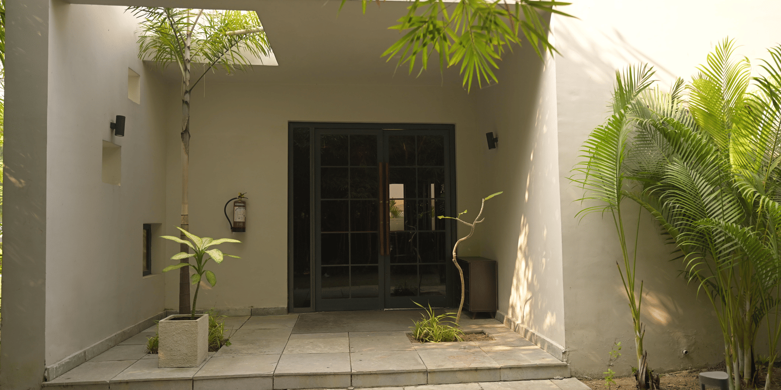 A quiet spa entrance framed by plants and soft natural light at Hotel Sonar Bangla Mayapur.
