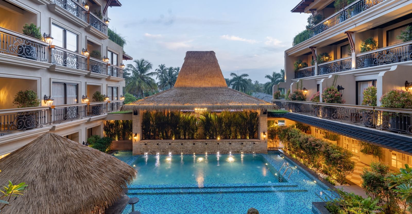 The swimming pool at The Evren, Vagator, between 2 building complexes during the early evening hours.