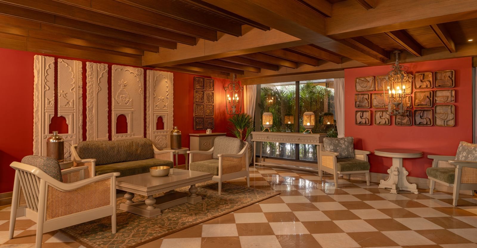 A beautiful lobby area at The Evren, Vagator, with red-coloured walls and a intricate interiors.