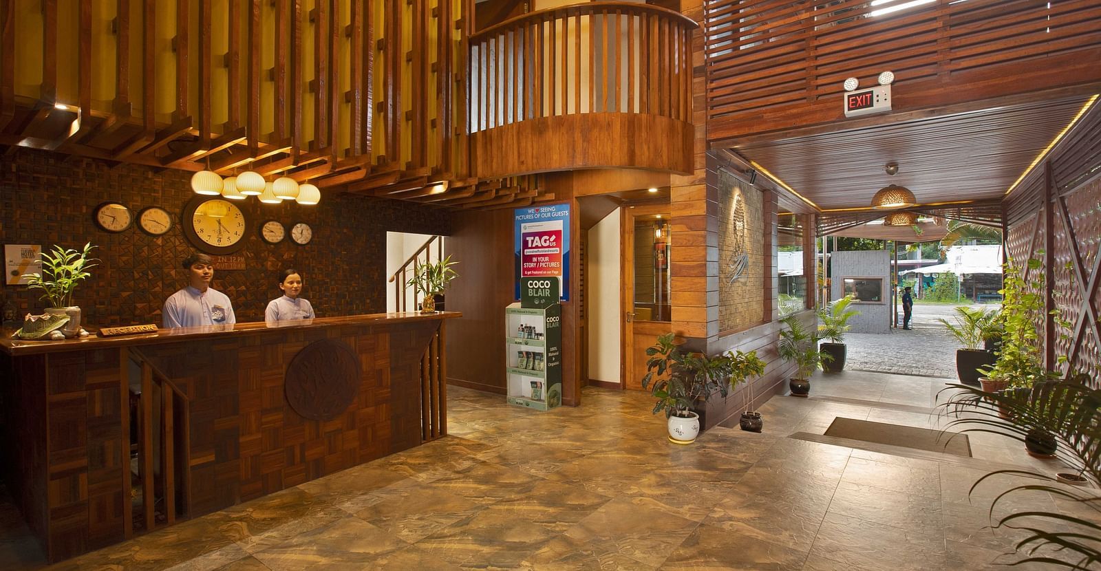 A stylish reception area with wooden paneling and decorative lighting. The lobby features a welcoming atmosphere with tropical plants and a sleek, modern design - Coral Reef Resort & Spa, Havelock