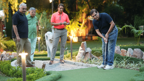 Participants playing golf on a miniature golf course at a golf event