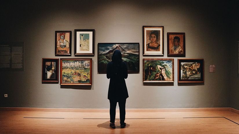 A person looking at art on a wall in front of them