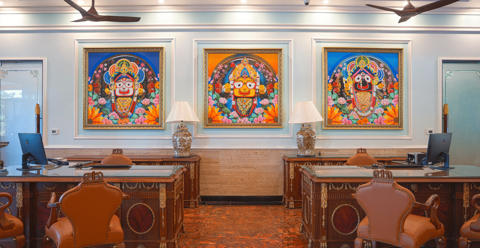 Front office lobby featuring three traditional artworks, wooden desks, and dark seating at MAYFAIR Bay Resort, Paradeep.