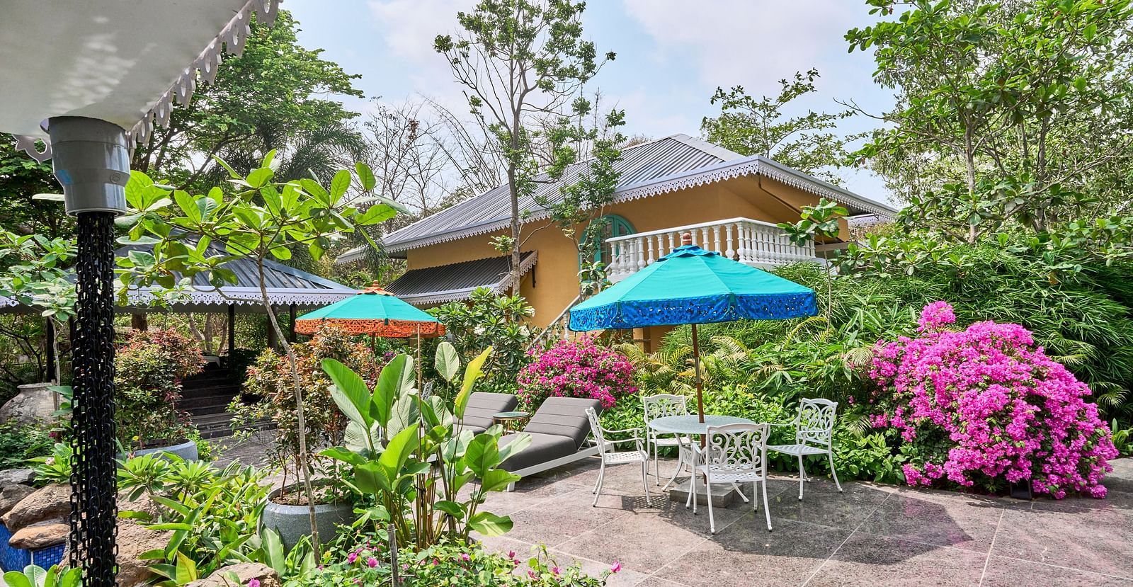 The exterior view of Mayfair Manor, Alibag, framed by trees and plants surrounding the property