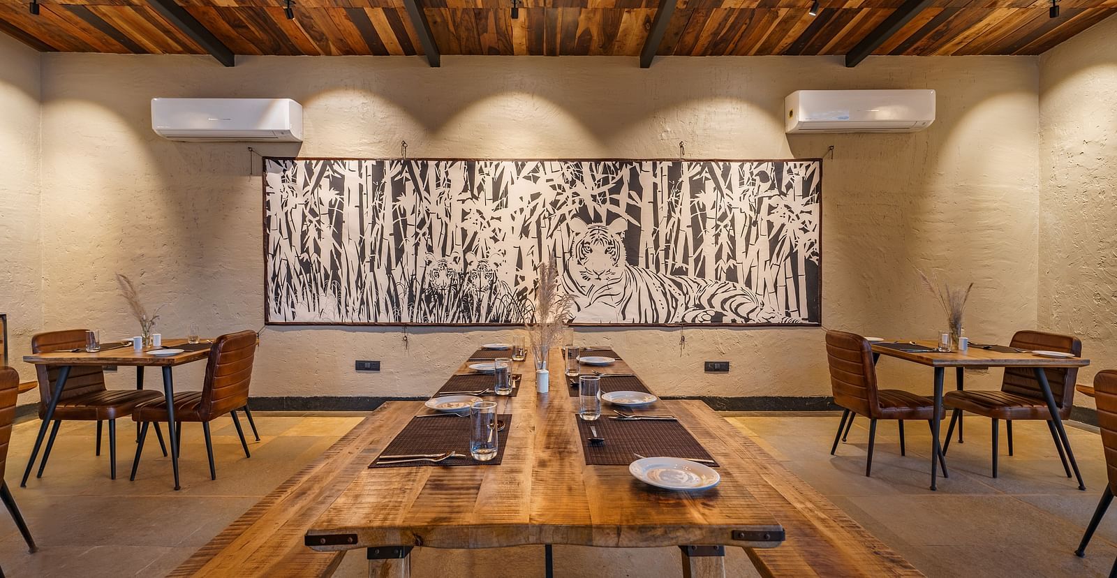 The dining area with wooden benches and tables and chair for seating at Trees N Tigers, Tadoba.