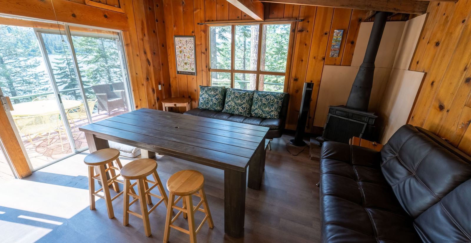 Cabin-style living space with dining table and sofas inside Kit Carson Lodge.
