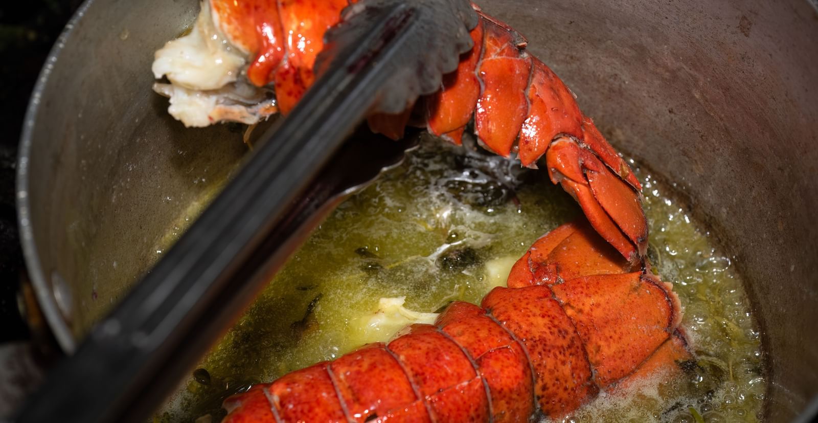 Lobster tails being seared in a pan with butter as part of a seafood dish prepared at the Narrow Gauge Inn kitchen.