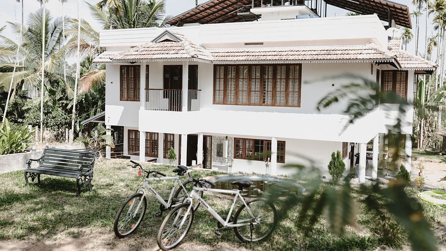 2 bicycles standing in front of the Facade of Ananda Holiday Home, Wayanad
