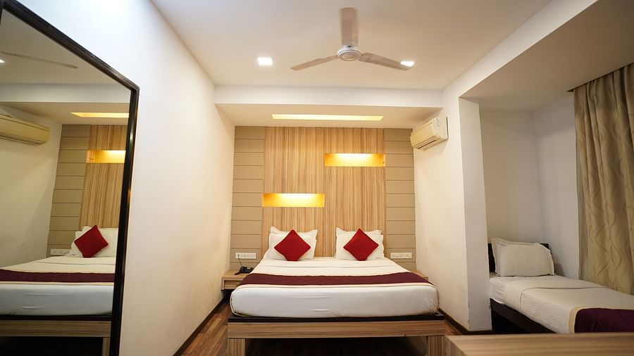 An image of executive deluxe room with a bed and a fan hanging from the ceiling at  City Centre Residency, Bangalore