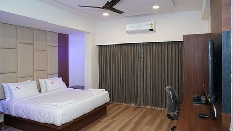 the suite room with a work desk and chair placed right opposite to the double bed - Hotel Grand Sigma