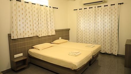A shot of the bedroom with a bed, nightstands, and curtains.