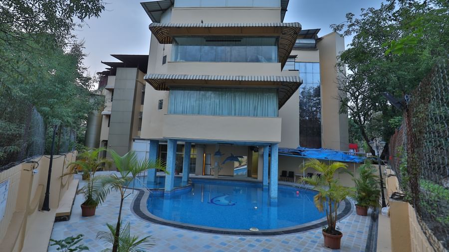 The exterior of a multi-story hotel building with a visible swimming pool in the foreground - Retreat Heritage, Lonavala