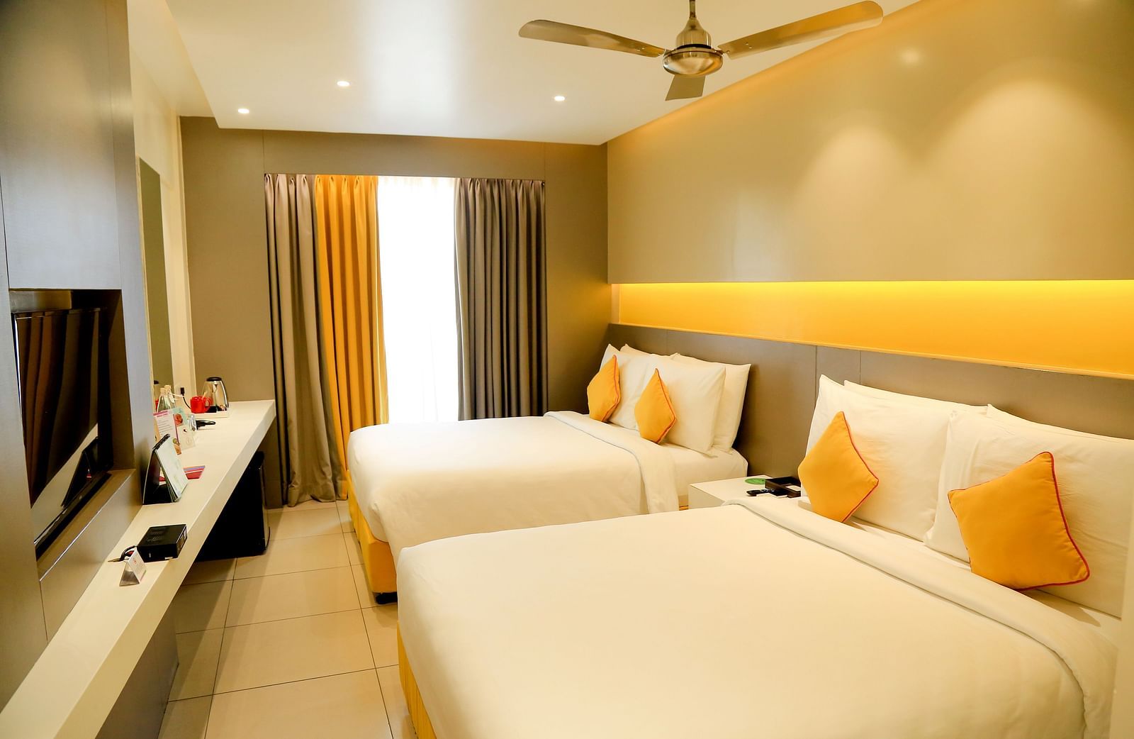  Spacious twin beds with headboards line the wall, large windows with curtains cover them