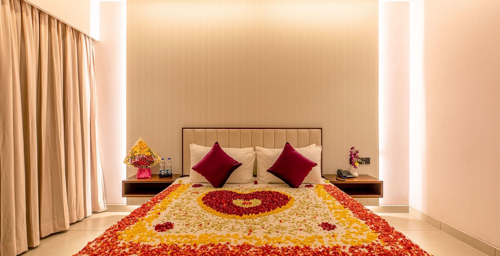 An image of a bed decorated with flower petals, featuring a heart shape in the center and an abundance of petals scattered around the sides at M Pro Palace.