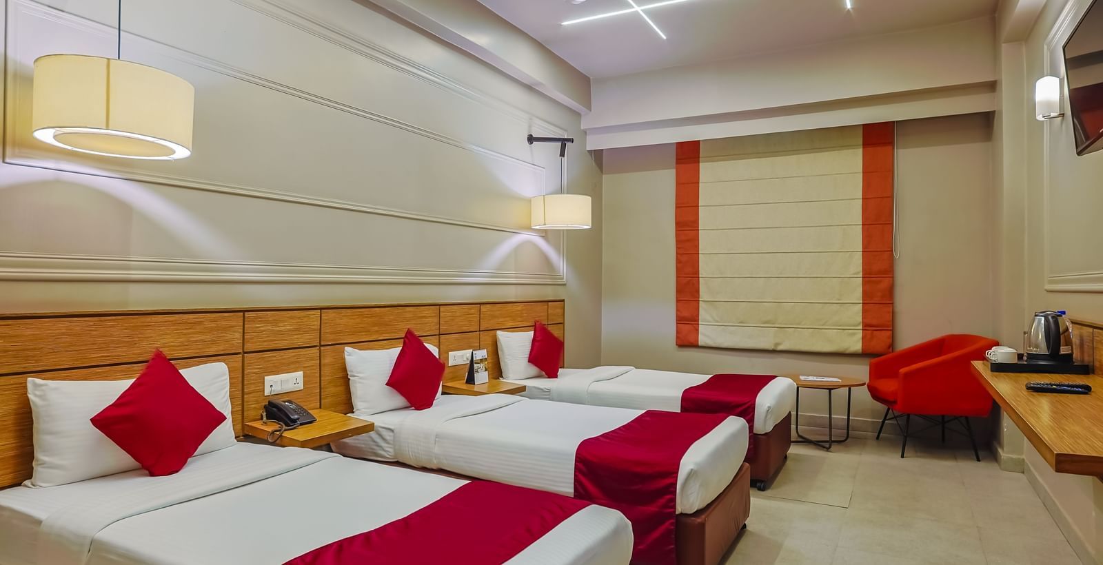 Spacious room with three single beds and modern design at Max Hotel Prayagraj.