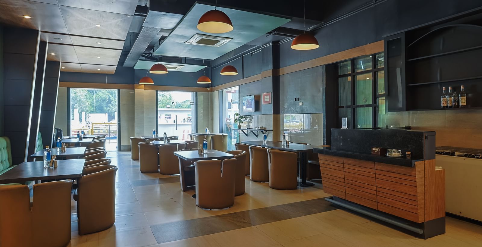 Spacious restaurant with tables, chairs and large windows at Max Hotel Prayagraj.