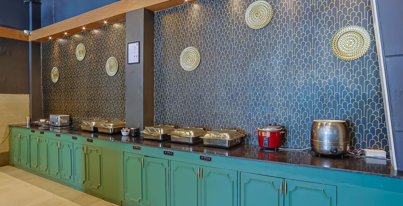 Buffet setup with utensils, chafing dishes and counters at Max Hotel Prayagraj.