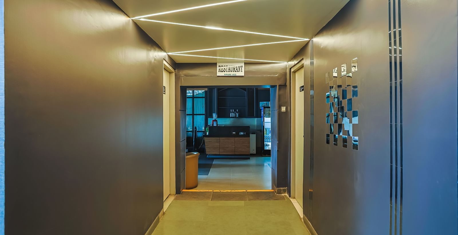 Corridor with modern ceiling lights and wall decor at Max Hotel Prayagraj.