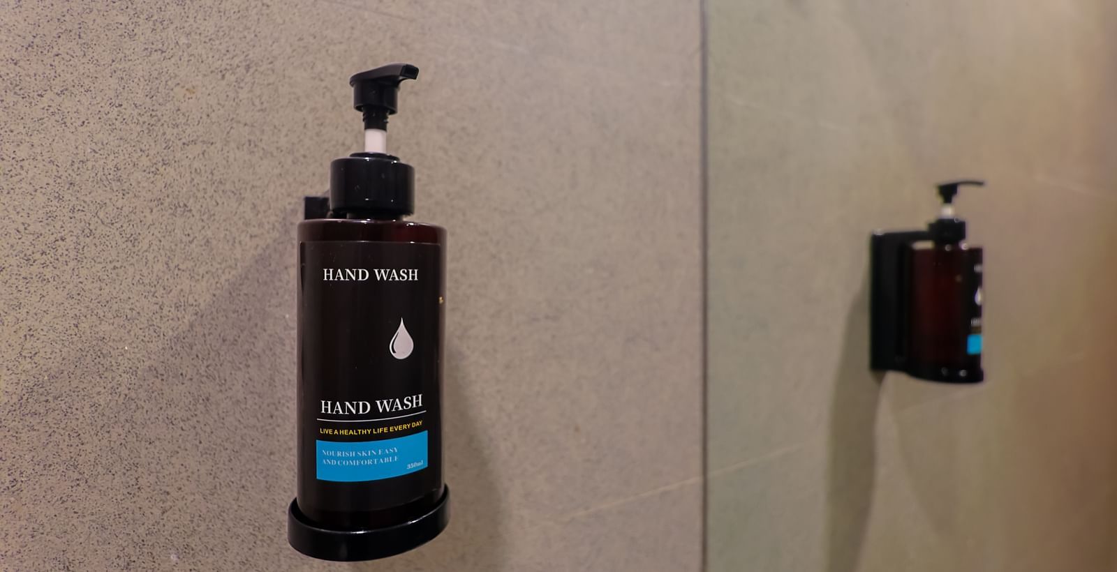 Wall-mounted shampoo dispenser at Max Hotel Prayagraj.