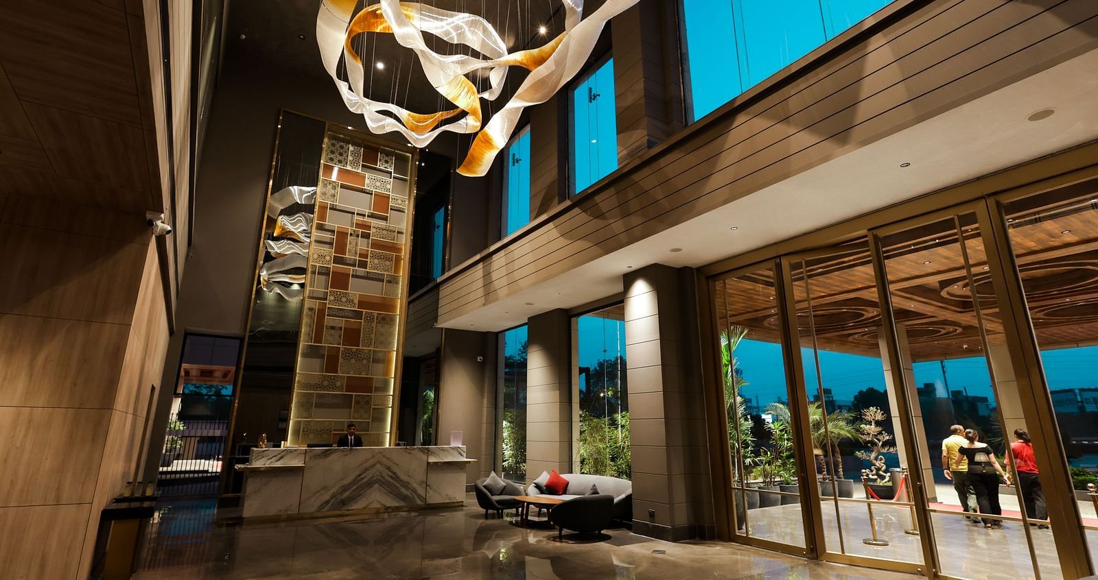 Grand hotel entrance lobby with tall windows and statement chandelier at Ramada by Wyndham Sonipat Murthal