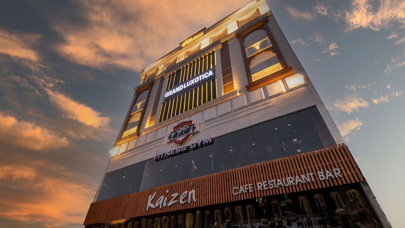 An angular shot of the facade of DLS Grand Luxotica, Dehradun under a vibrant twilight sky