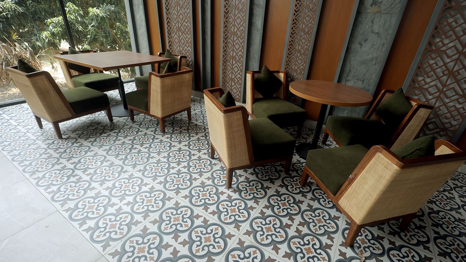 Sophisticated indoor dining with patterned flooring and upholstered wooden armchairs beside tall windows at Wyndham Garden.