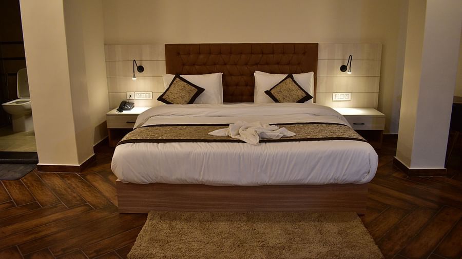 Deluxe Room - a pristine white bed with soft linens and clean pillows designed with soft lights and aesthetic interior1 - Hotel Montana Vyoo