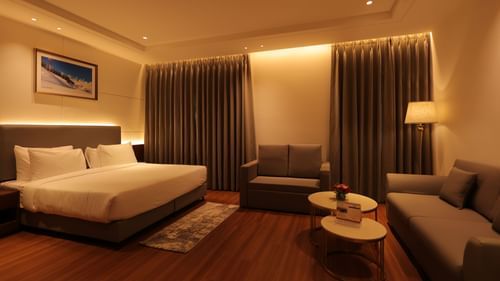 view of king size bed  and comfortable sofas of Premium Room at Pride Elite, Haridwar