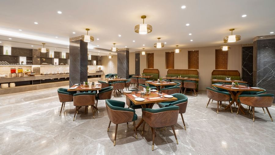Spacious restaurant with a large buffet table and tables with chairs - Clarks Inn, Indore